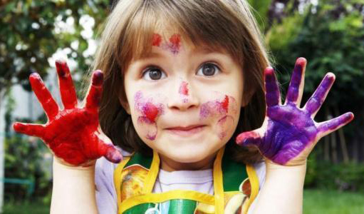 玩彩画的小女孩，满脸和双手沾满颜料
